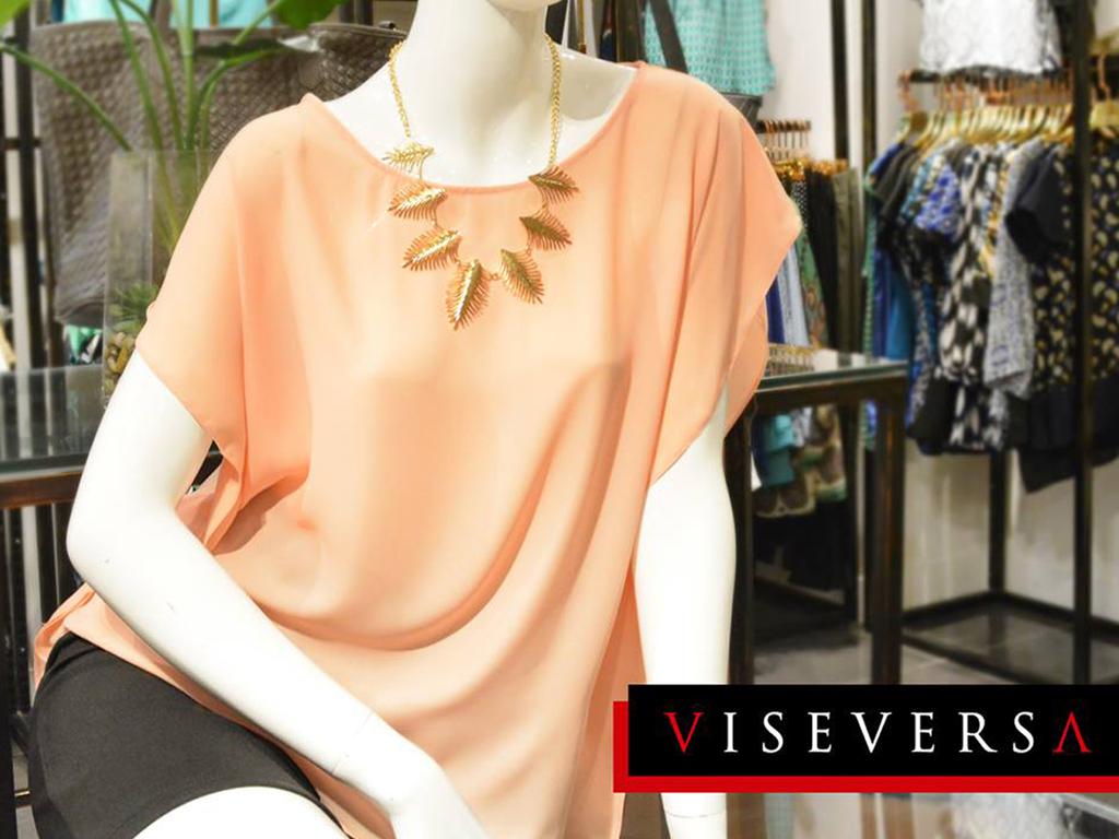 Try dressing up a plain blouse like this peach top with a statement necklace for a polished look